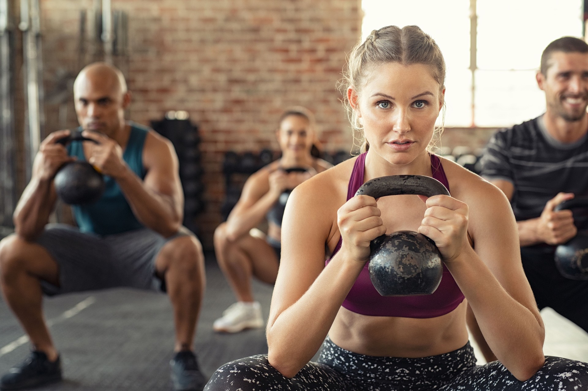 Fitness woman squatting with kettle bell